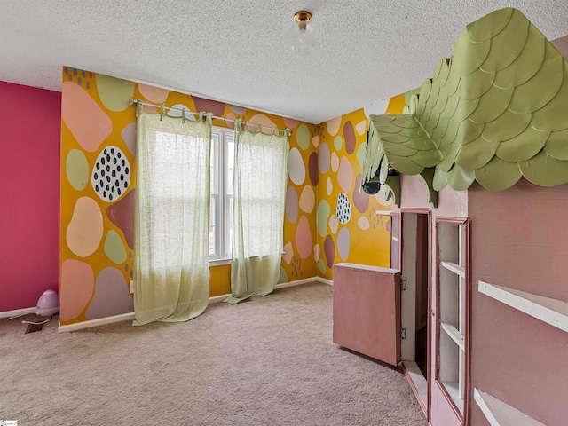 recreation room featuring carpet, a textured ceiling, and baseboards