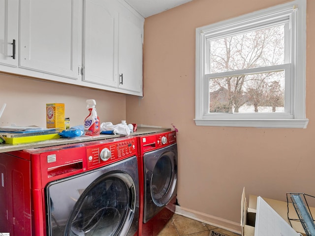 laundry room with washing machine and dryer, cabinet space, baseboards, and light tile patterned floors