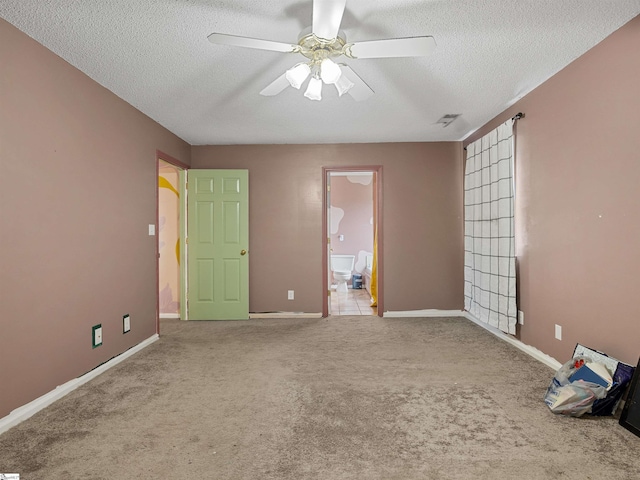 carpeted spare room with visible vents, ceiling fan, a textured ceiling, and baseboards