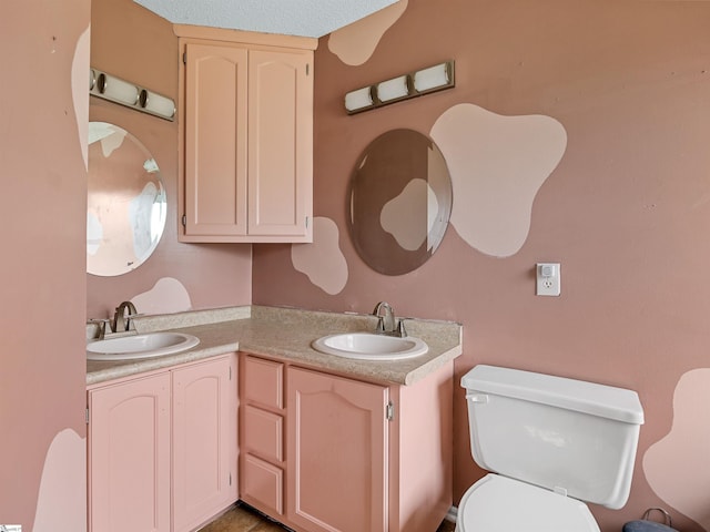 full bath with a sink, toilet, and double vanity