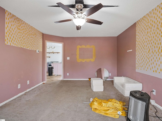 interior space with ceiling fan, baseboards, a textured ceiling, and carpet flooring