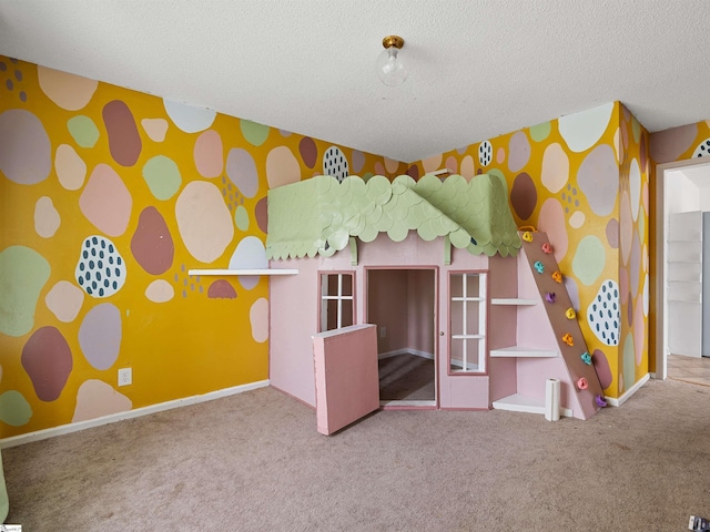 unfurnished bedroom featuring carpet floors, an accent wall, a textured ceiling, baseboards, and wallpapered walls