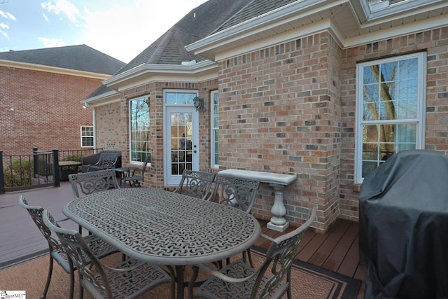 wooden deck with outdoor dining area and grilling area