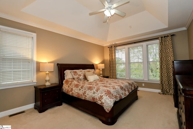 bedroom featuring light colored carpet, visible vents, baseboards, a tray ceiling, and crown molding