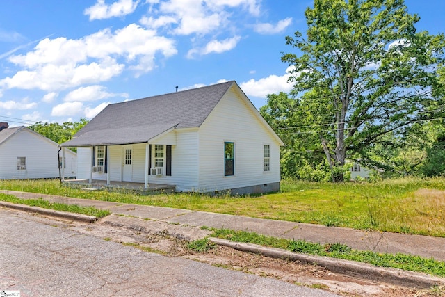 view of front of property featuring a shingled roof, a front yard, covered porch, and crawl space