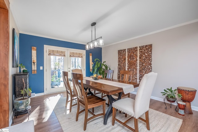 dining space with ornamental molding, french doors, wood finished floors, and baseboards