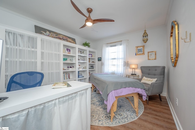 bedroom featuring ceiling fan, ornamental molding, wood finished floors, and baseboards