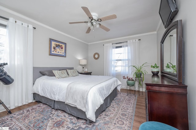 bedroom with ornamental molding, a ceiling fan, and wood finished floors