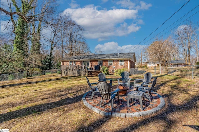 view of yard with an outdoor fire pit, a fenced backyard, and a wooden deck