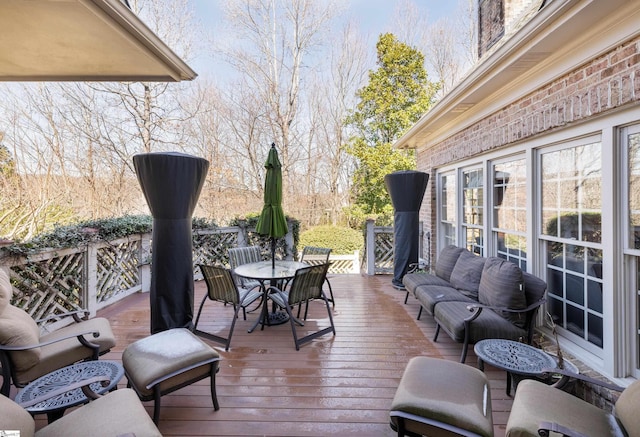 wooden terrace with outdoor dining area and outdoor lounge area