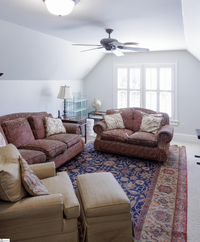 living room featuring carpet floors, vaulted ceiling, baseboards, and ceiling fan