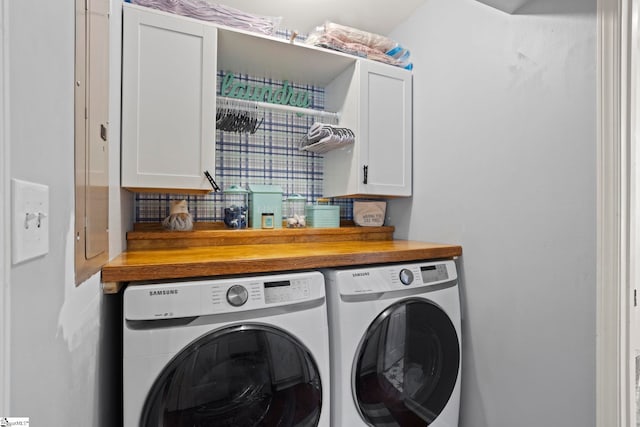 laundry room featuring washing machine and clothes dryer and cabinet space