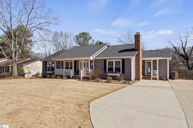 ranch-style home featuring a porch, a shingled roof, a chimney, and a front lawn