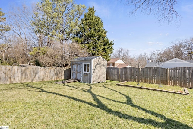 view of yard featuring an outbuilding, a shed, and a fenced backyard