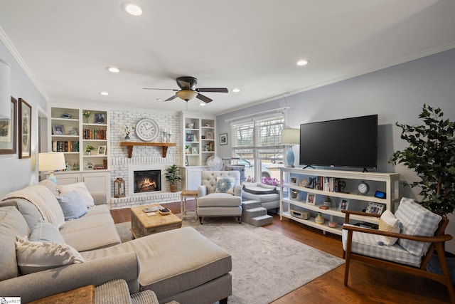 living area featuring built in features, recessed lighting, ornamental molding, a ceiling fan, and wood finished floors