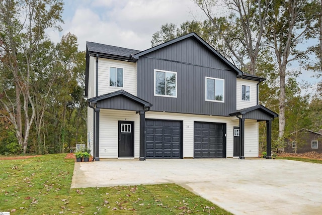 view of front of home with a front lawn, concrete driveway, and an attached garage