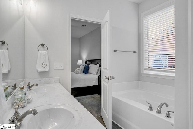 ensuite bathroom with a bath, ensuite bath, double vanity, and a sink