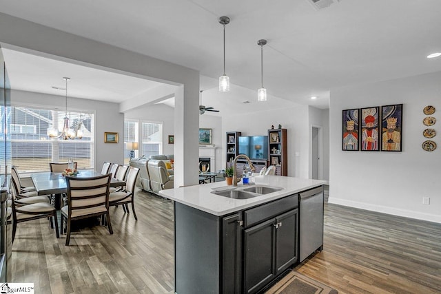 kitchen with a fireplace, a sink, open floor plan, light countertops, and dishwasher