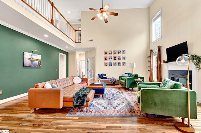 621 Shefwood Dr, Easley, SC 29642 - living area with ornamental molding, a glass covered fireplace, visible vents, and wood finished floors