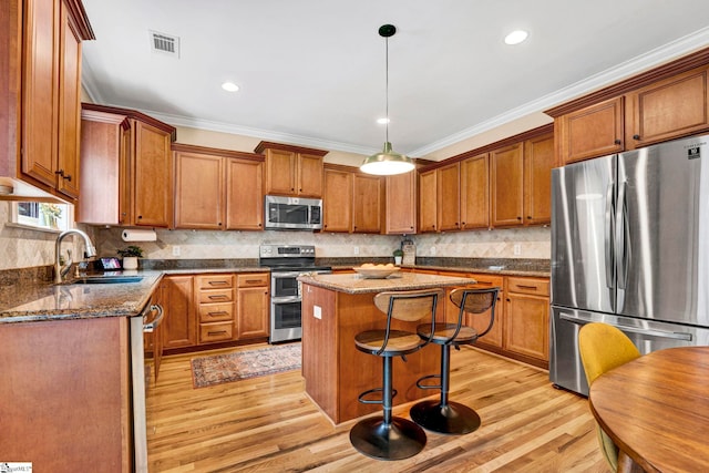 621 Shefwood Dr, Easley, SC 29642 - kitchen featuring visible vents, appliances with stainless steel finishes, brown cabinets, ornamental molding, and a sink