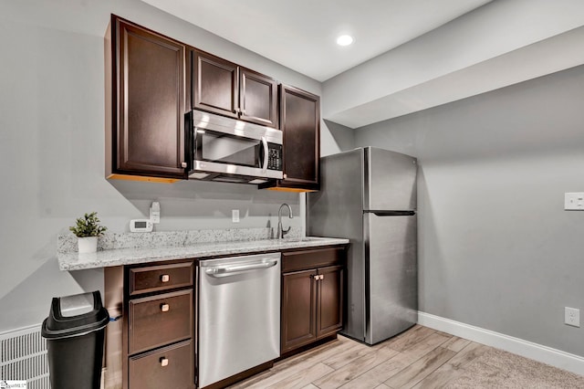 621 Shefwood Dr, Easley, SC 29642 - kitchen featuring stainless steel appliances, light wood-style floors, a sink, dark brown cabinetry, and baseboards