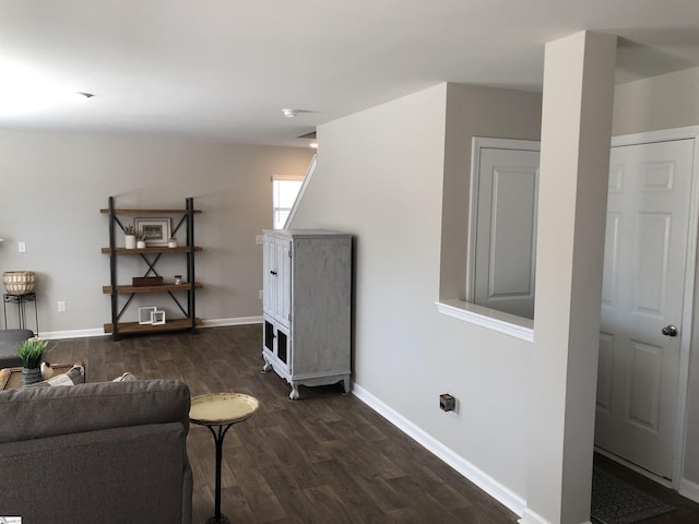 living room featuring dark wood-type flooring and baseboards