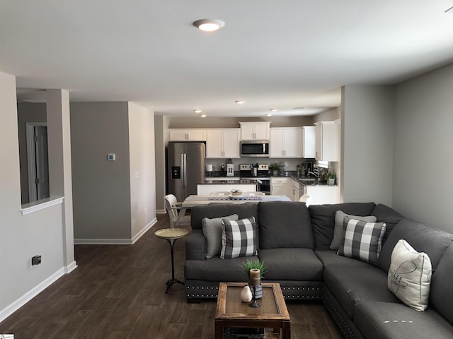 living room featuring recessed lighting, dark wood finished floors, and baseboards