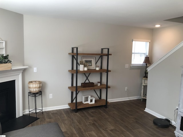 living room with stairs, a fireplace, baseboards, and wood finished floors