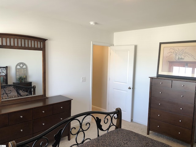 bedroom featuring light carpet and baseboards