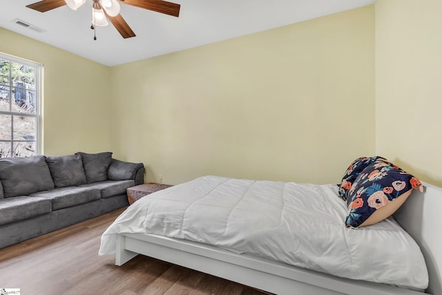 bedroom featuring visible vents, ceiling fan, and wood finished floors