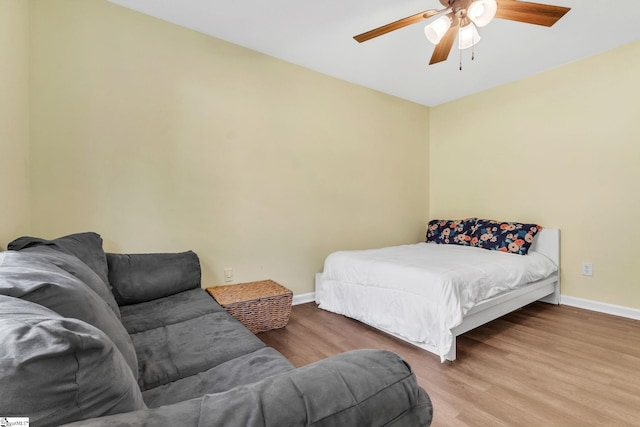 bedroom with a ceiling fan, baseboards, and wood finished floors