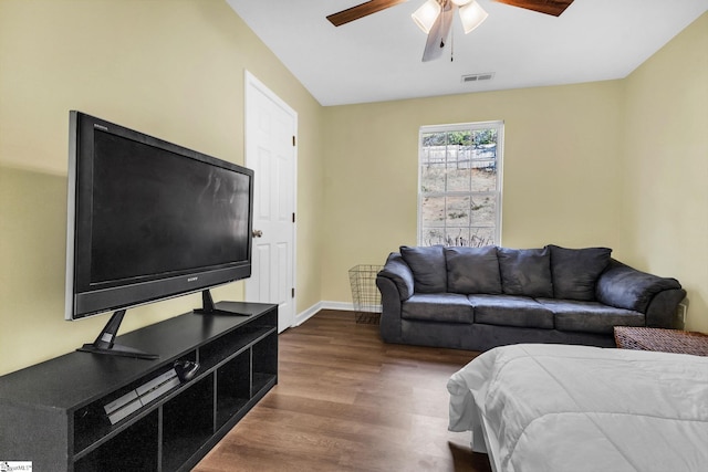 living area with dark wood-type flooring, visible vents, ceiling fan, and baseboards