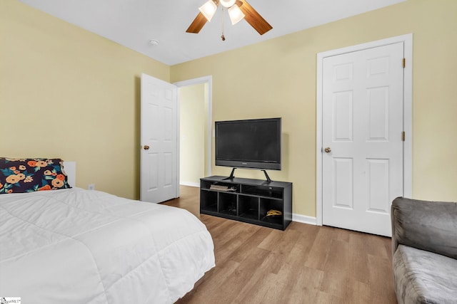 bedroom featuring wood finished floors, a ceiling fan, and baseboards