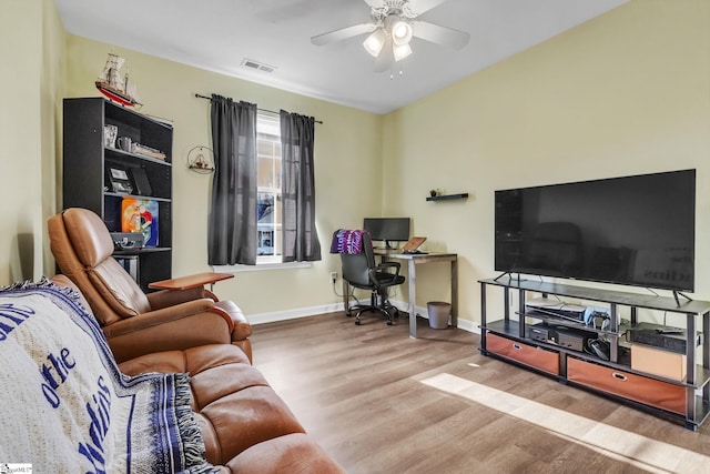 living area with baseboards, ceiling fan, visible vents, and wood finished floors