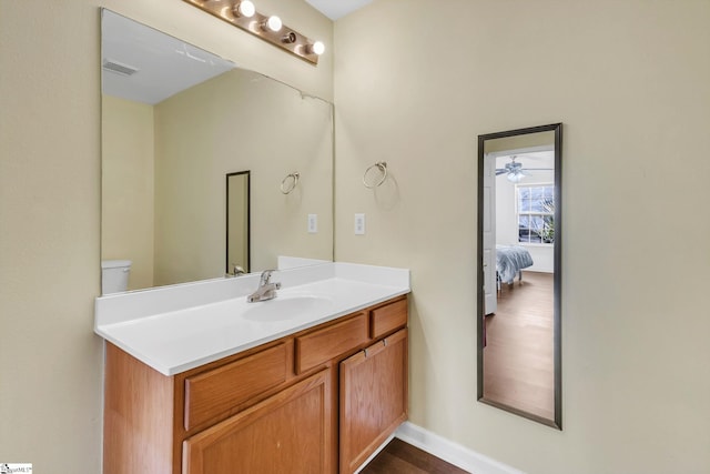 ensuite bathroom with visible vents, toilet, vanity, ensuite bath, and baseboards