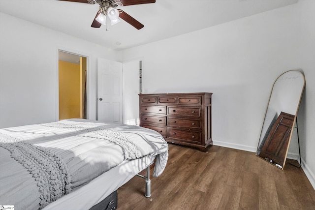 bedroom with dark wood-type flooring, a ceiling fan, and baseboards