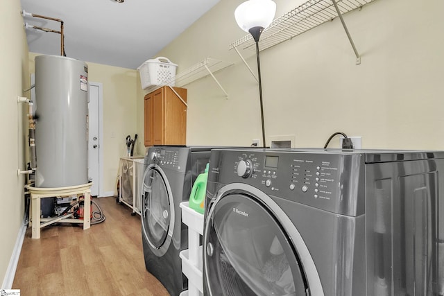 laundry area featuring gas water heater, washer and clothes dryer, light wood-type flooring, laundry area, and baseboards