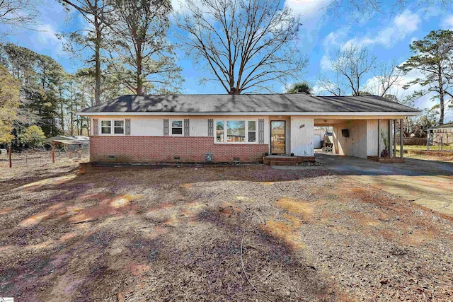 single story home with an attached carport, crawl space, brick siding, and driveway