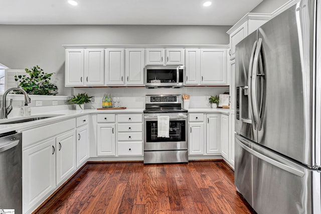 kitchen with dark wood-style floors, appliances with stainless steel finishes, light countertops, and a sink