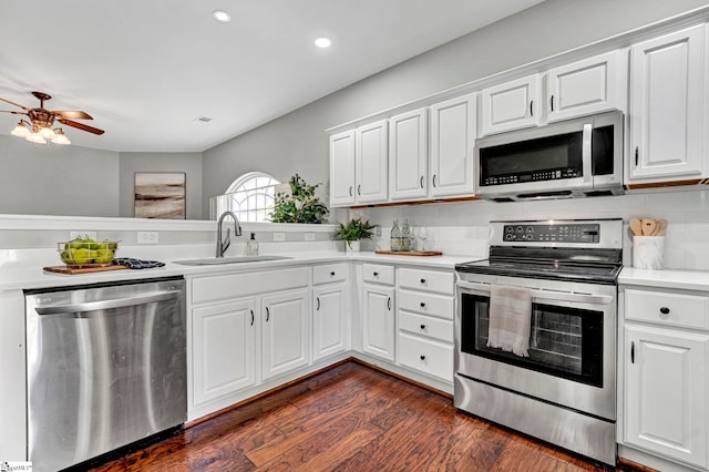 kitchen featuring light countertops, appliances with stainless steel finishes, dark wood-type flooring, white cabinets, and a sink