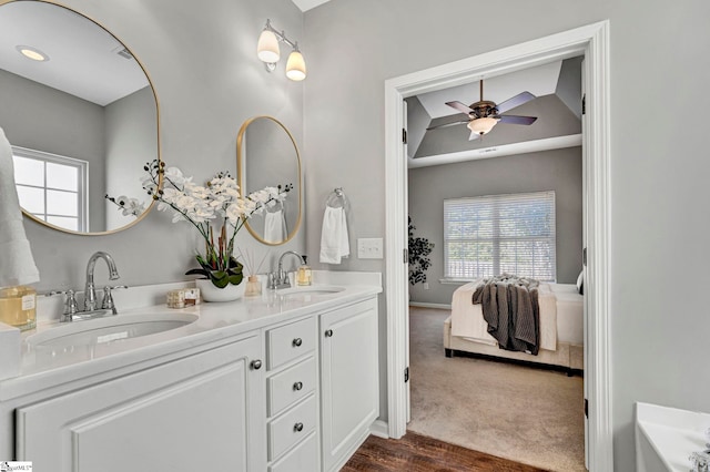 bathroom with ceiling fan, double vanity, ensuite bath, and a sink