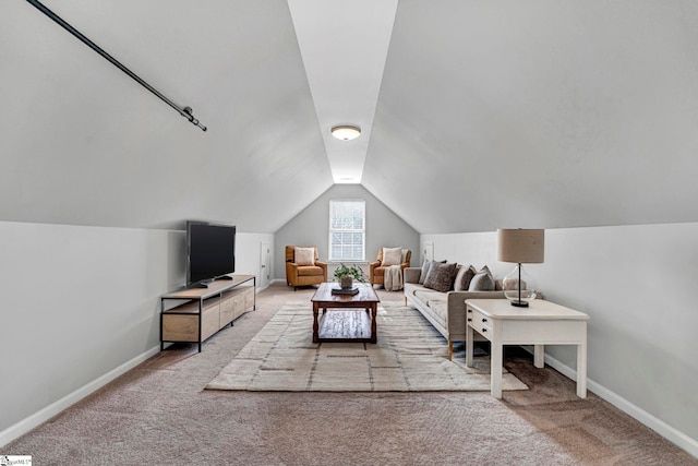 living room with carpet floors, lofted ceiling, and baseboards