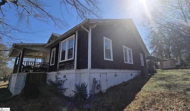 view of property exterior with central AC unit, crawl space, and a porch