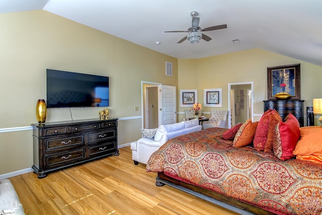 bedroom with light wood-style floors, baseboards, visible vents, and vaulted ceiling