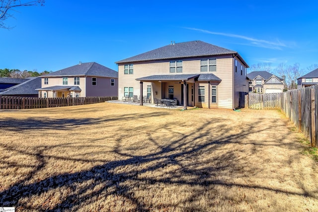 back of property featuring a yard, roof with shingles, a patio area, and a fenced backyard