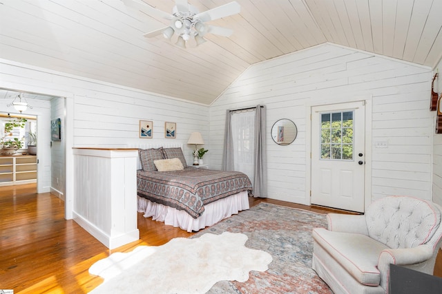 bedroom featuring vaulted ceiling, wood finished floors, wood ceiling, and wooden walls