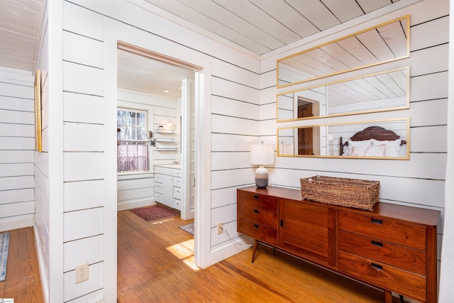 hallway with wooden walls and hardwood / wood-style floors