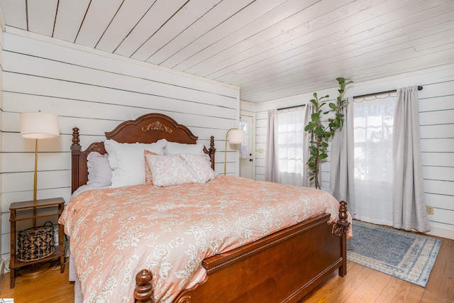 bedroom with light wood-type flooring and wooden ceiling