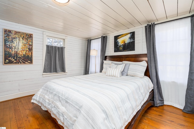 bedroom with wood walls, wood-type flooring, and wooden ceiling