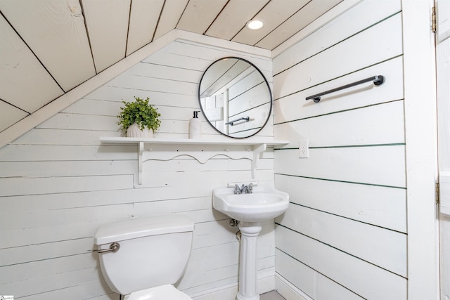 bathroom with toilet and wooden walls